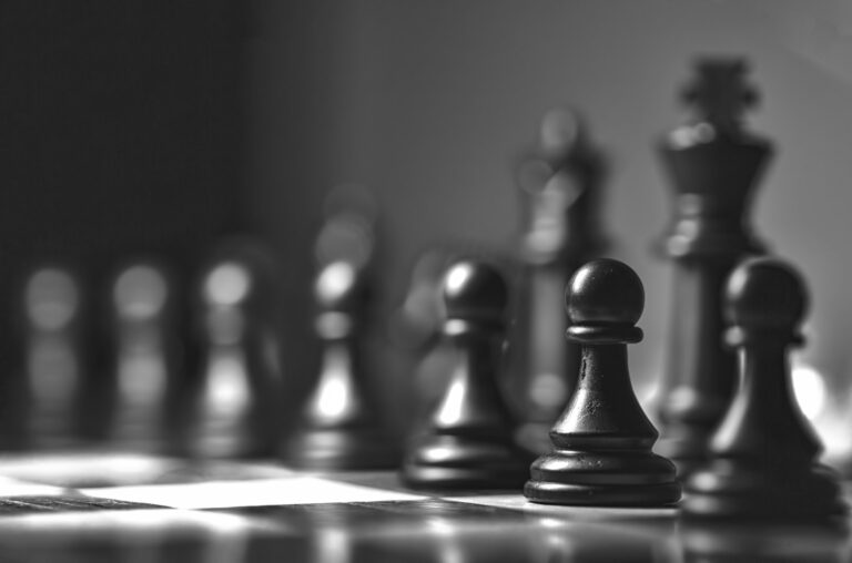 Piezas de ajedrez sobre un tablero, en blanco y negro